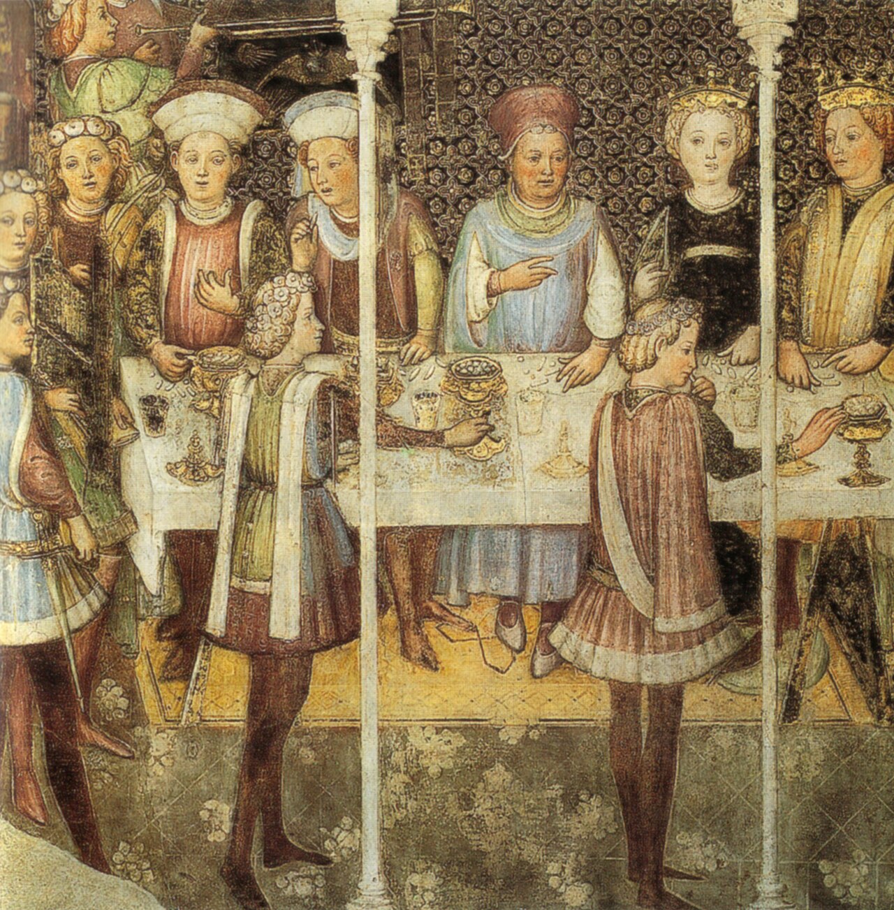 Affresco medievale con figure nobili e regali, donne e uomini in abiti riccamente decorati, sfondo dorato.